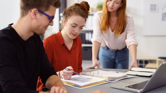 Des jeunes discutent autour d'un ordinateur.