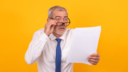 Un homme regarde attentivement un document.