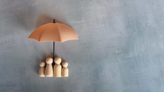 des figurines en bois sous un parapluie