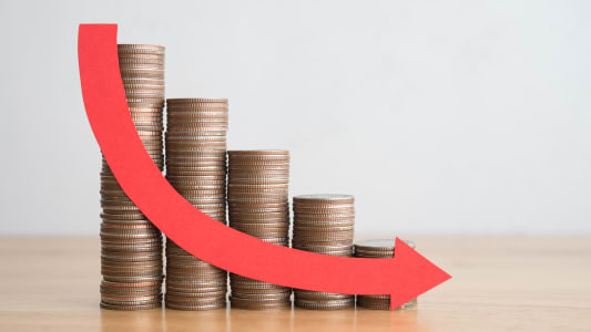 Plusieurs piles de pices et une flche vers le bas.