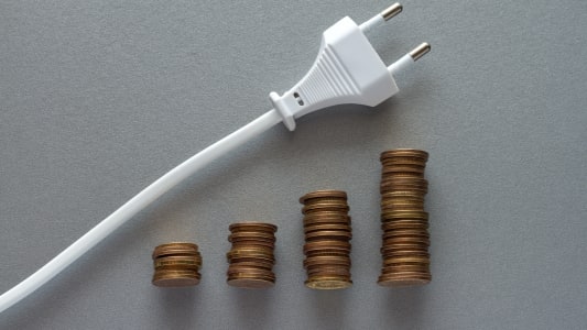 Une prise lectrique et des piles de pices pour symboliser la hausse des prix.