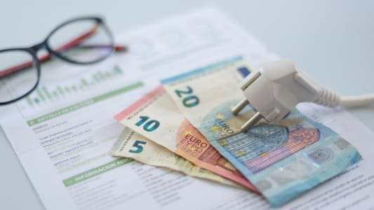 Un document et des billets entours d'un fil lectrique.