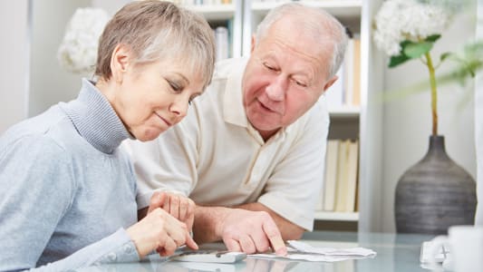 Deux soixantenaires regardent un document.