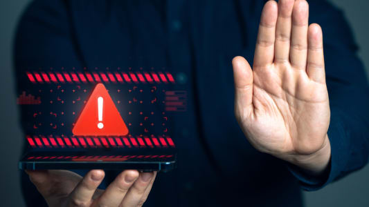 Une personne fait le signe stop avec sa main.