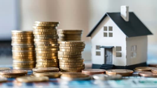 Une maison miniature avec des piles de pi�ces.