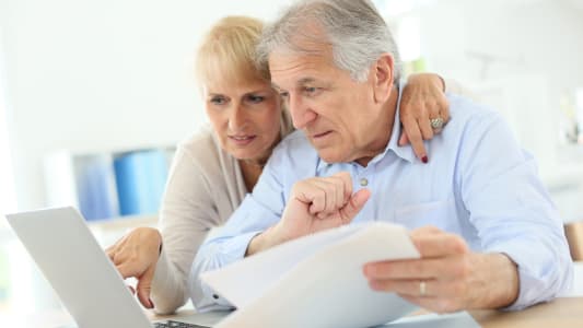 Un couple de seniors regarde des documents.