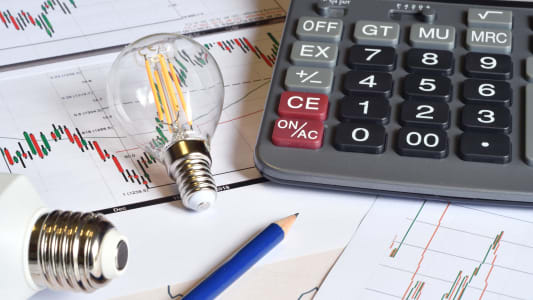 Une ampoule une calculatrice et des documents.