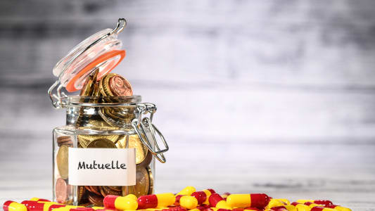 Des mdicaments entourent un bocal portant l'inscription mutuelle et rempli de pices de monnaie,