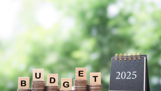 Sur des piles de pièces, des lettres portant l'inscription Budget 2025