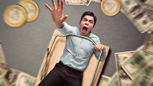 Un homme coinc� dans un pi�ge essaie d'attraper de l'argent.