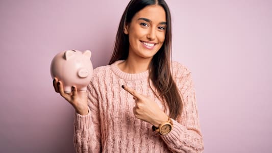 Une femme tient une tirelire.