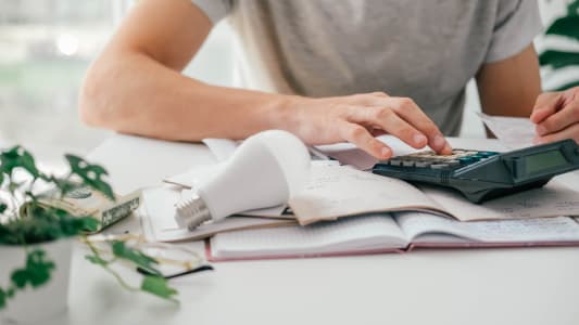 Un homme utilise une calculatrice.