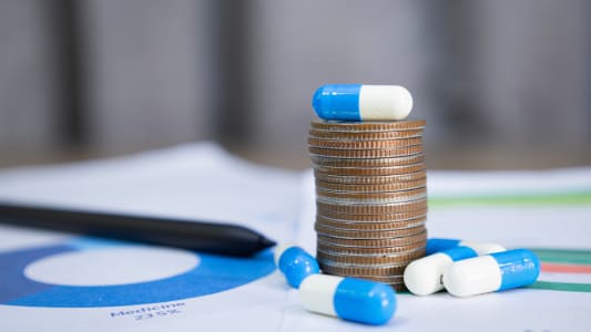 Des m�dicaments et une pile de pi�ces de monnaie.