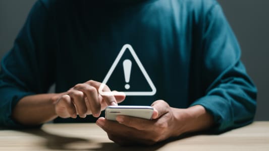 Un tlphone affichant le panneau attention.