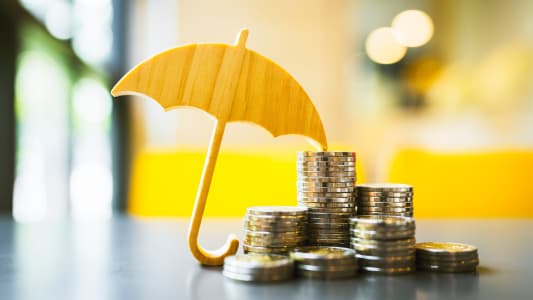 Un parapluie et des piles de pices de monnaie.