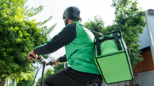 Un livreur à vélo.