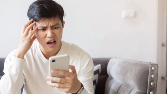 Un homme l'air effray regarde son tlphone