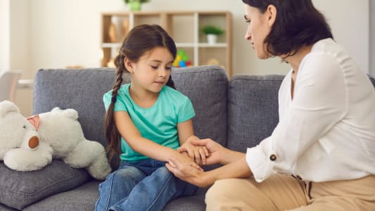 Une femme et un enfant se tiennent les mains.