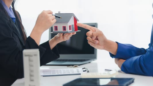 Une maison miniature dsigne et un contrat.