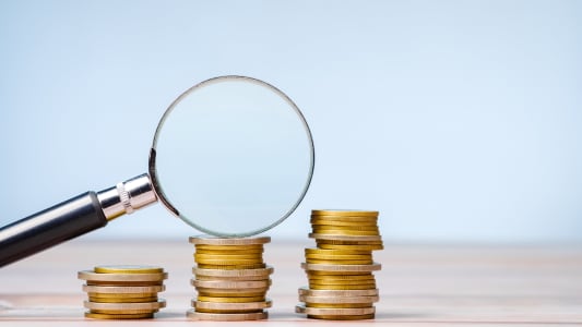 Une loupe et des pièces de monnaie.