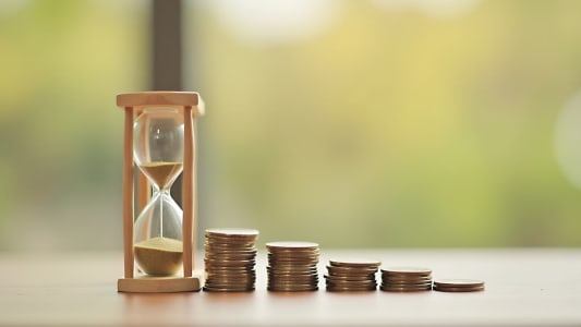 Un sablier et des pices de monnaie.