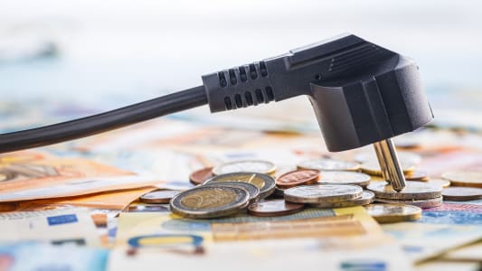 Des billets et pices de monnaie et une pris lectrique.