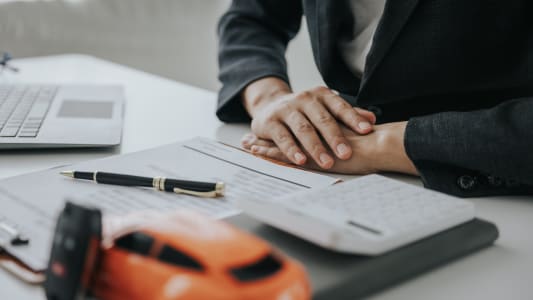 Une voiture miniature, une calculatrice et des documents.