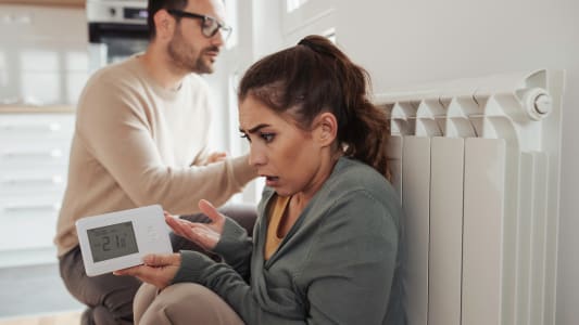 Un homme et une femme prs d'un radiateur.