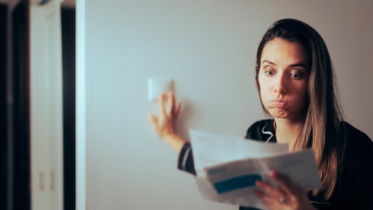 Une femme regarde un document l'air perplexe.