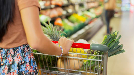 Une femme fait ses courses dans un supermarché.