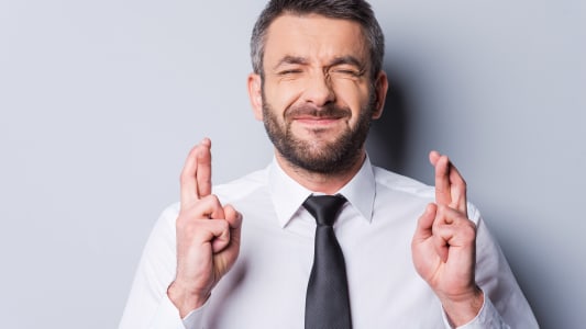 Un homme croise les doigts.