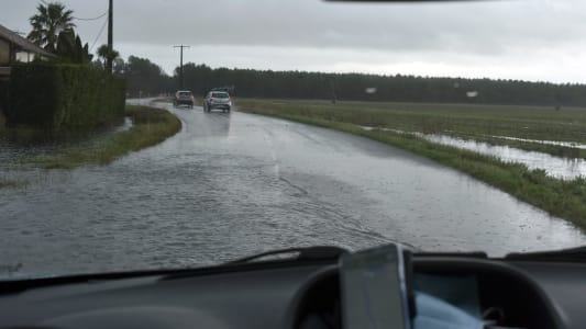 Des voitures sur une voie inonde.