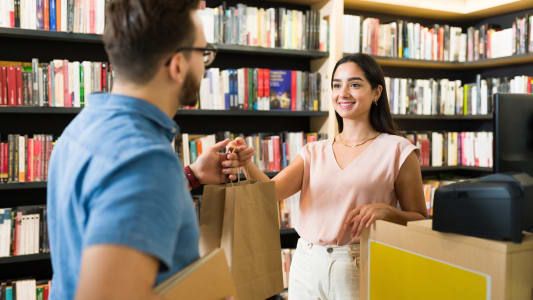 Une jeune femme achète des livres.
