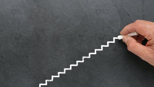 Quelqu'un trace un escalier sur un tableau.