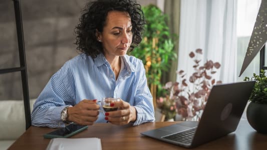 Une femme regarde son ordinateur.