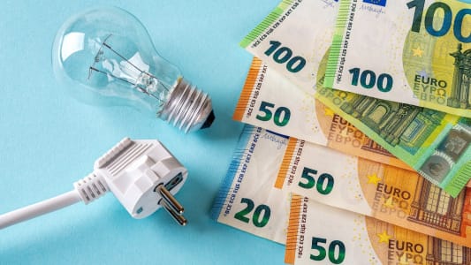 Des billets de banque, une prise et une ampoule.