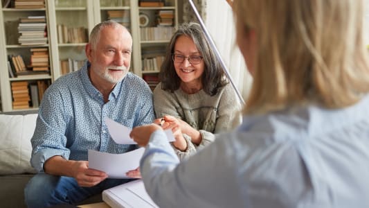 Un homme et une femme regardent des documents.