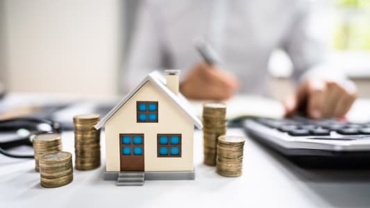 Une maison et des pièces de monnaie.