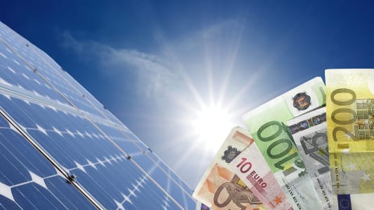 Des billets et des panneaux photovoltaques.