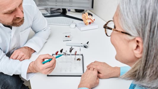 Une personnes regardent diffrents types d'aides auditives.