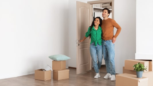 Un couple dans un logement avec des cartons.