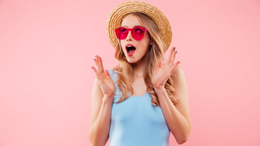Une femme porte un chapeau et a un air surpris.