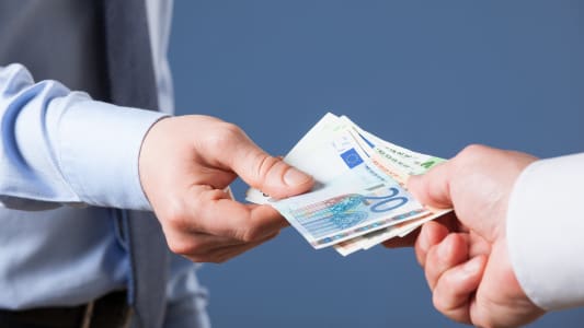 Une personne donne des billets � quelqu'un.