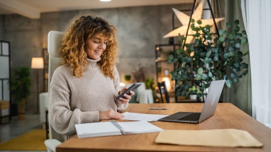 Une femme regarde son ordinateur.