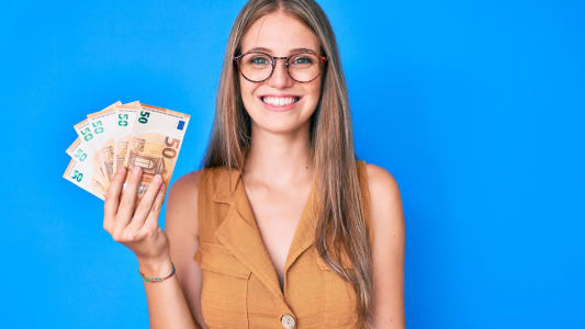 Une femme montre des billets de 50 euros.