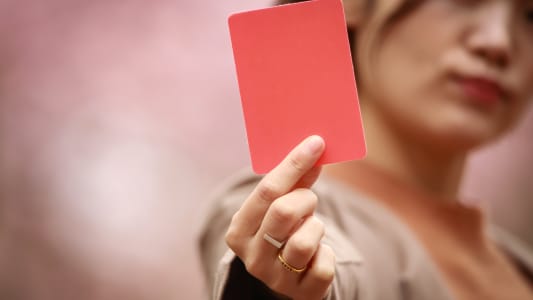 Une personne montre un carton rouge.