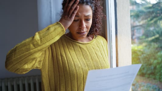 Une femme regarde un document avec inquitude.