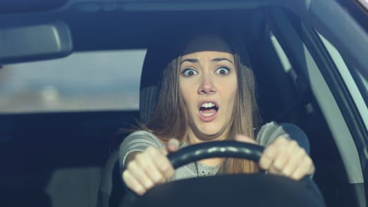 Une femme effraye dans une voiture.