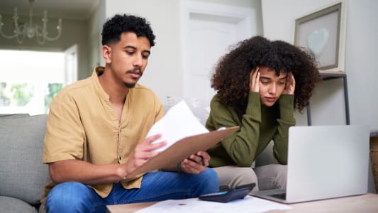 Deux personnes se questionnent devant des documents.