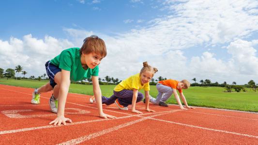Des enfants sur une piste d'athltisme.
